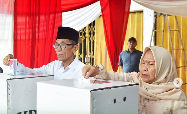 Wabup Bakhtiar dan Istri Berikan Hak Pilih dalam Pemilukada di TPS 004